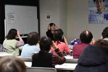 日焼け止めの塗り方をレクチャーする講師