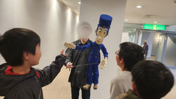 人形と触れ合う子どもたちの写真