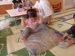 アクアビーズクッションに乗って楽しんでいる子どもの姿