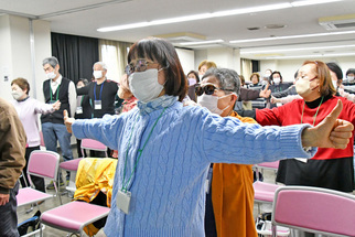 背筋を伸ばして腕を広げる女性