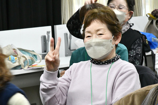 笑顔でぐー、ちょき、ぱーを出す女性