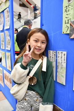 会場で展示されていた学校で作った作品の前でポーズをとる女の子