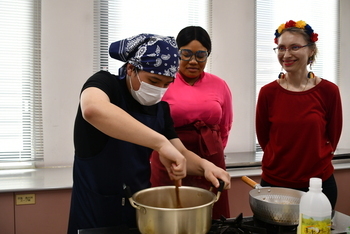 ゲストスピーカーに見守られながら鍋を混ぜる参加者