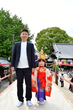 横に並んで笑顔で写真を撮る親子
