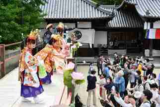 壇上から散華や厄よけのもちをまく子どもたち