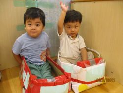 段ボール製のはたらく車に乗る子どもの写真