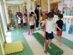 竹馬に乗る感覚を片足から練習する子どもの写真