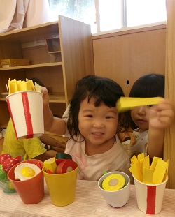 色々な素材を使って作ったフライドポテトを持ってポーズを決めている子ども様子。