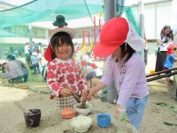 すり鉢で葉っぱをつぶしている子どもの写真