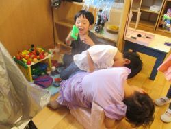 部屋のままごとスペースでバーベキューごっこを楽しむ子どもたちの写真