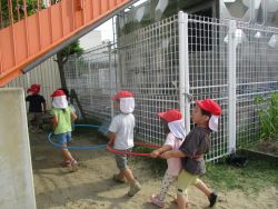 子どもたちがフープを前後でつなげて連なって遊んでいる様子