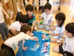 手作りの魚釣り道具で魚釣りを楽しむ子どもたちの写真