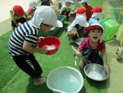 泡だて器を用いて泡遊びを楽しむ子どもたちの写真