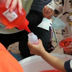 赤い色水を容器に入れてもらう