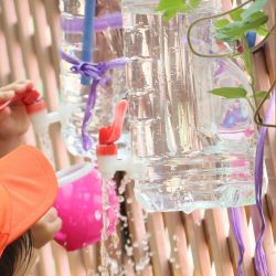蛇口から水を入れる子ども