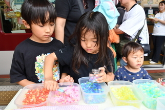 写真：こんぺいとうの瓶詰体験をする兄妹