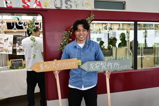 写真：ワークショップの看板を持つスタッフ
