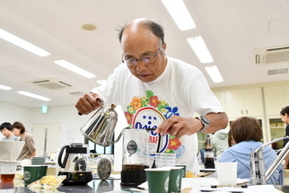 写真：フレンチプレスでコーヒーを抽出する参加者