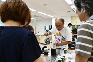 写真：フレンチプレスにお湯を注ぐ参加者