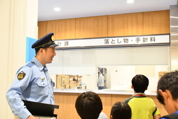 八尾警察署新庁舎を見学するこどもたちと案内する警察官