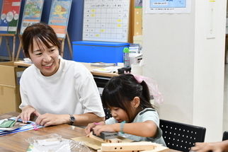 笑顔で木製スツール制作を楽しむ親子
