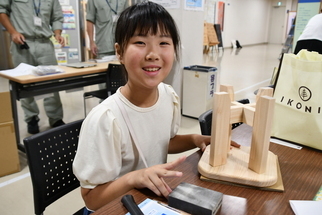 完成した木製スツールを見せる笑顔の女の子