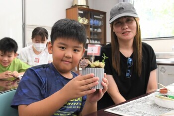 完成した多肉植物の寄せ植えを手に持つ児童