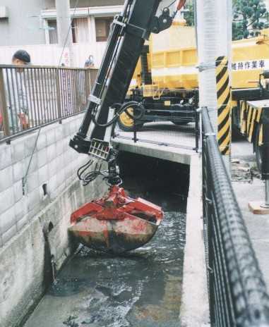 比較的幅が広くて周囲に障害物が少ない水路は、 クレーンを使って直接泥をくみ上げます。